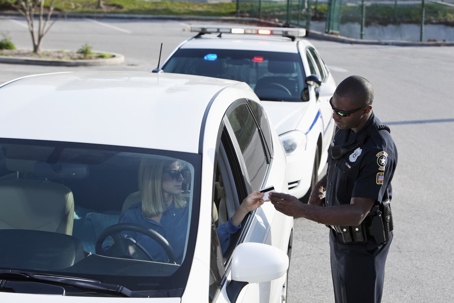 Woman showing officer her identification after being pulled over.